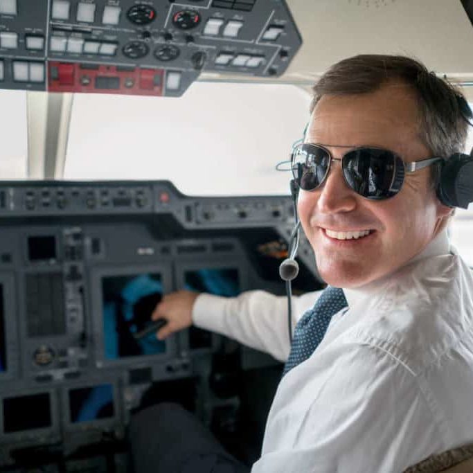 Handsome male pilot flying a private plane and wearing headset